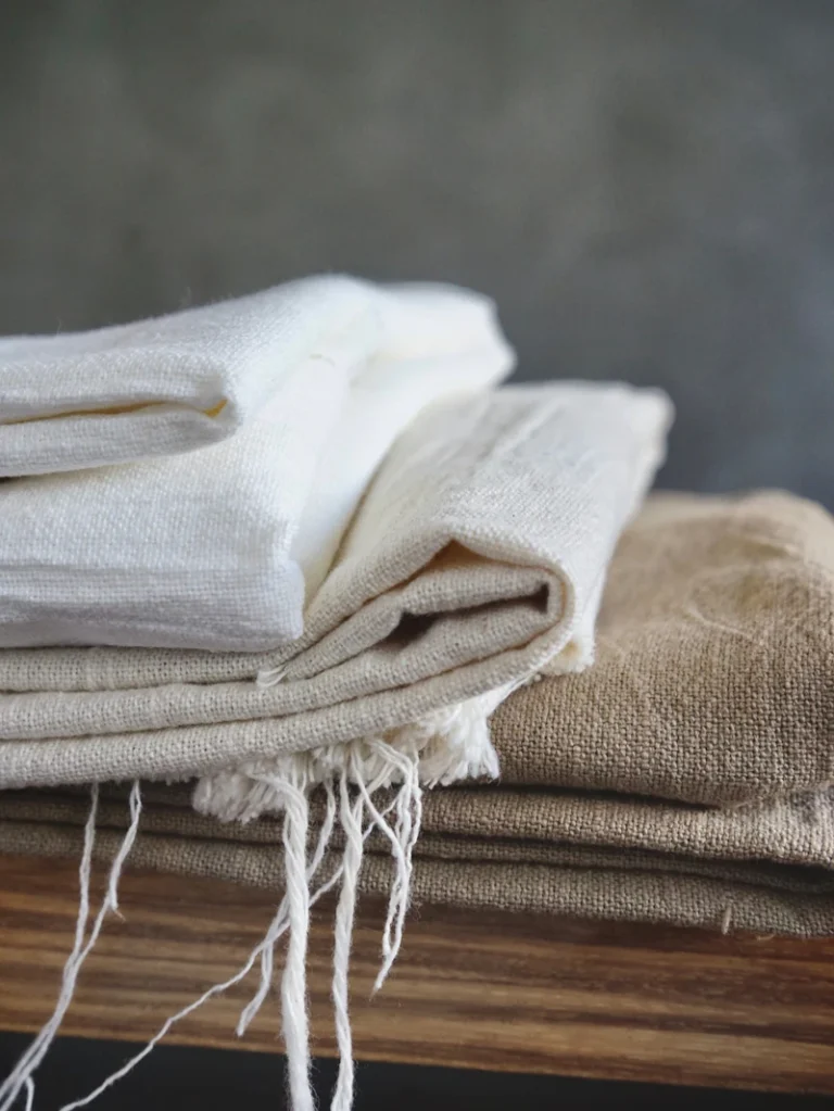 Tumpukan linen putih dan krem yang sudah dilipat