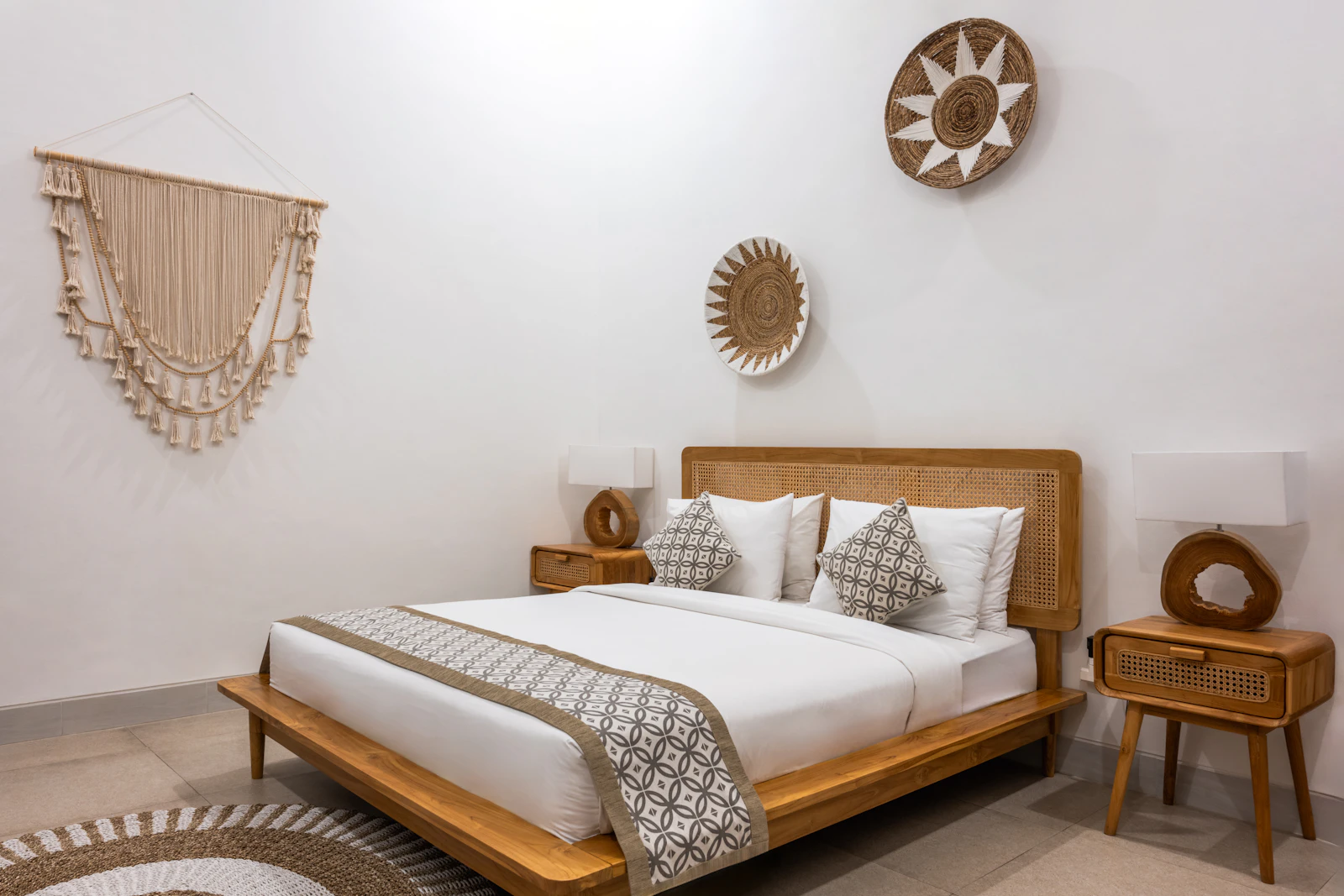 Kamar villa dengan sprei putih, bed runner, dan cahaya alami